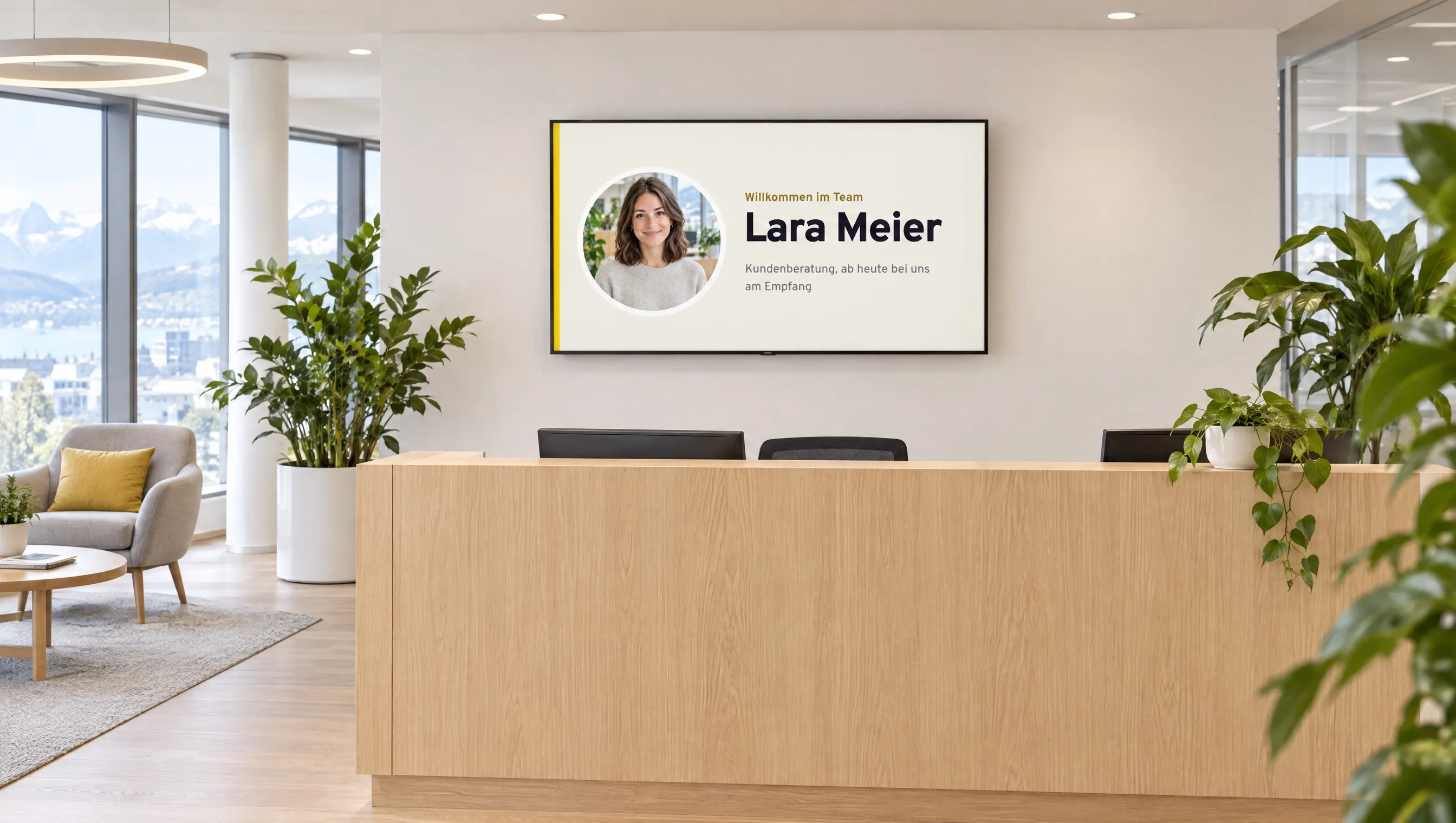 Büro-Empfang, auf dem Bildschirm die Begrüssung einer neuen Mitarbeiterin